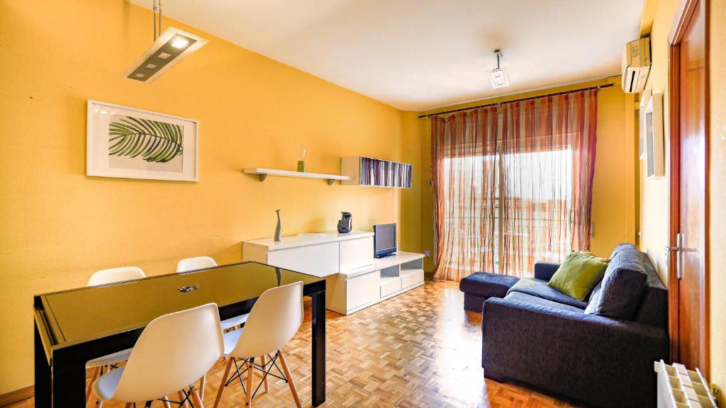 a living room with a couch and a table and chairs at Bed&Bcn Sant Andreu in Barcelona