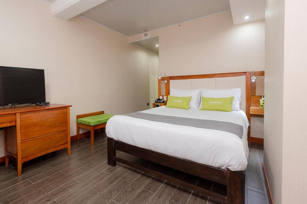 a hotel room with a bed and a television at Ayenda La Luna Inn in Lima