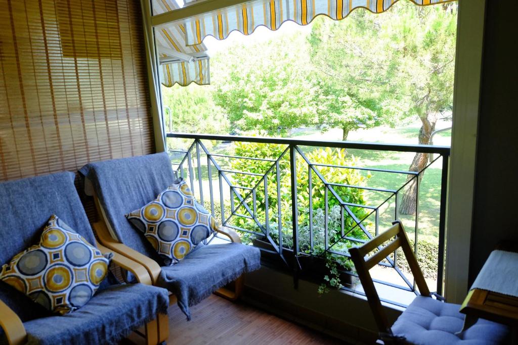 Elle comprend un balcon avec deux chaises et une grande fenêtre. dans l'établissement Studio Flat close to Terme, à Sirmione