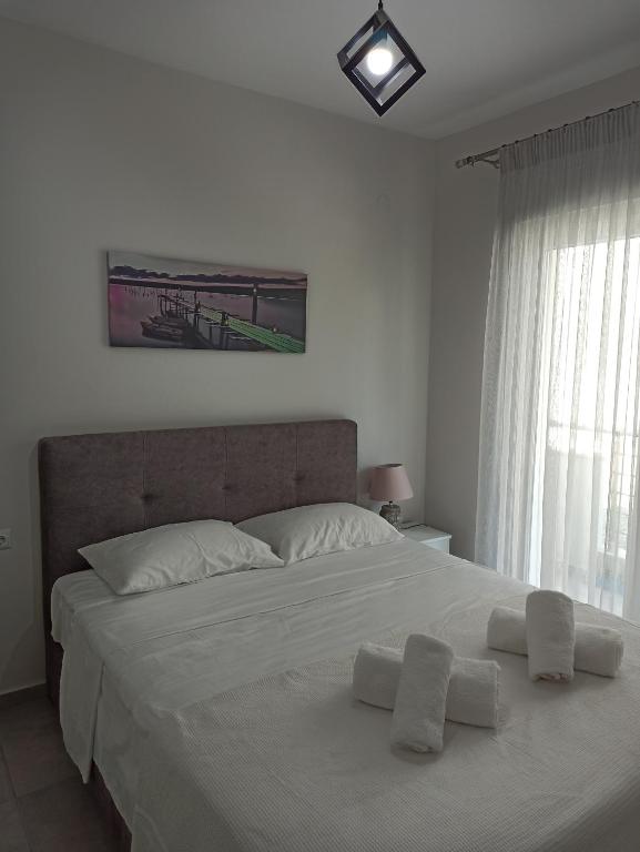 a bedroom with a large bed with two white pillows at Steps to the sea in Nea Peramos