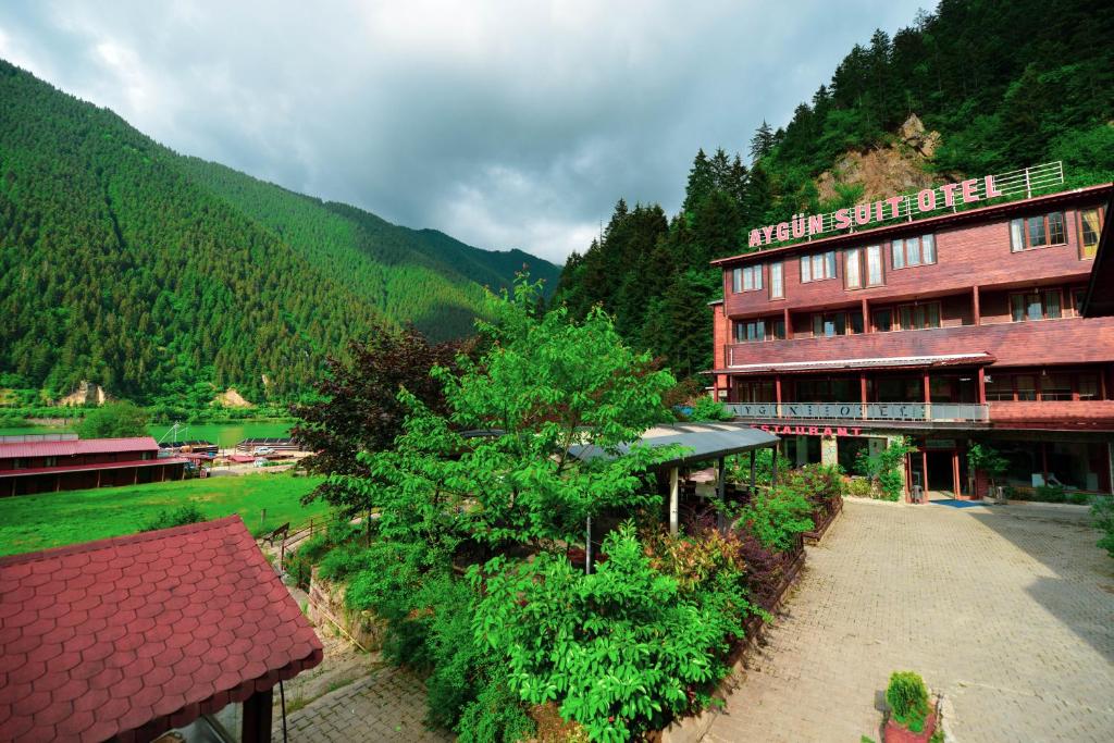 ウズンギョルにあるAygün Suites Hotel&Bungalow UZUNGÖLの山を背景にしたホテルの建物