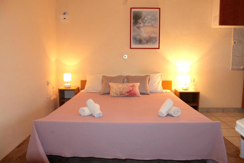 a bedroom with a large white bed with two lamps at Apartments Nature in Omiš