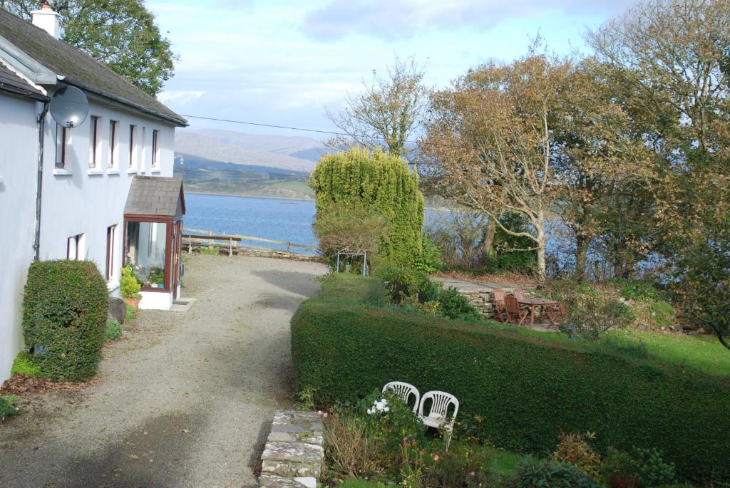 a house with a garden and a view of a lake at Dromcloc House in Bantry