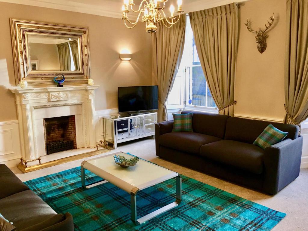 a living room with a couch and a fireplace at Escape to Edinburgh @ Abercromby Place in Edinburgh