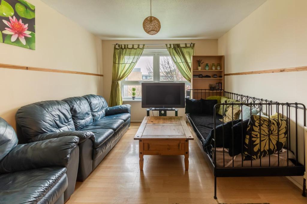 a living room with a couch and a tv at EDINBURGH CITY CENTRE AISHIA/SAKINA APARTMENT in Edinburgh