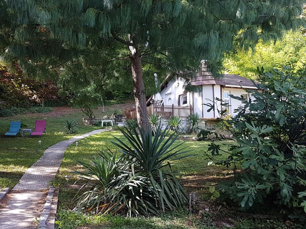une maison dans une cour avec un arbre et un chemin dans l'établissement Ambition Zen Presles, à Presles
