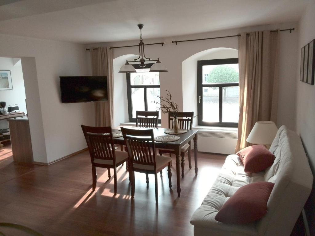 ein Wohnzimmer mit einem Sofa, einem Tisch und Stühlen in der Unterkunft Altstadt Apartments in Querfurt