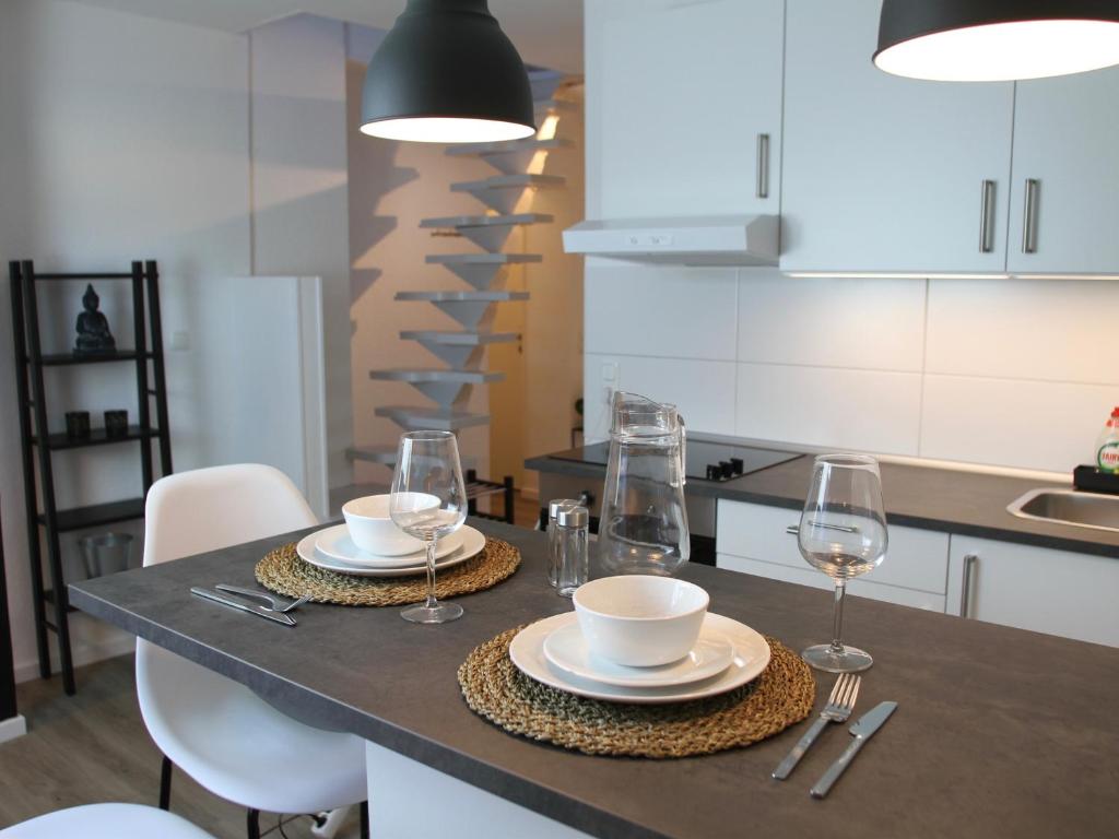 uma cozinha com uma mesa com pratos e copos de vinho em Apartmenthaus in der Arnoldstraße em Bochum