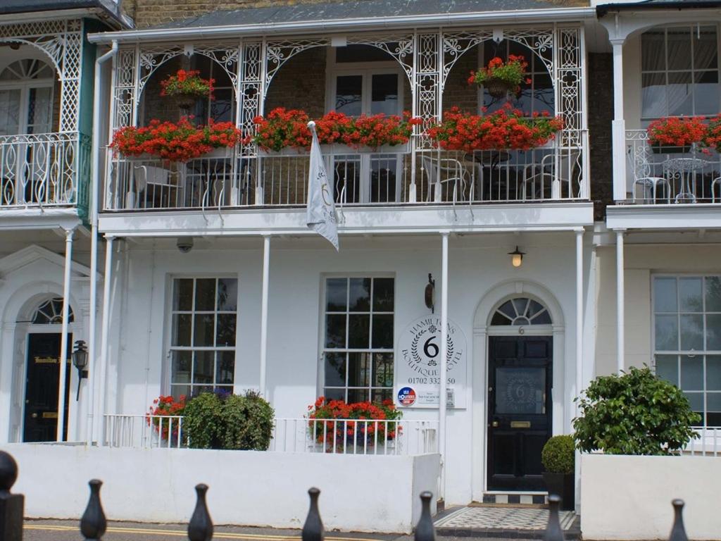 a white building with flower boxes and windows at Hamiltons Boutique Hotel in Southend-on-Sea