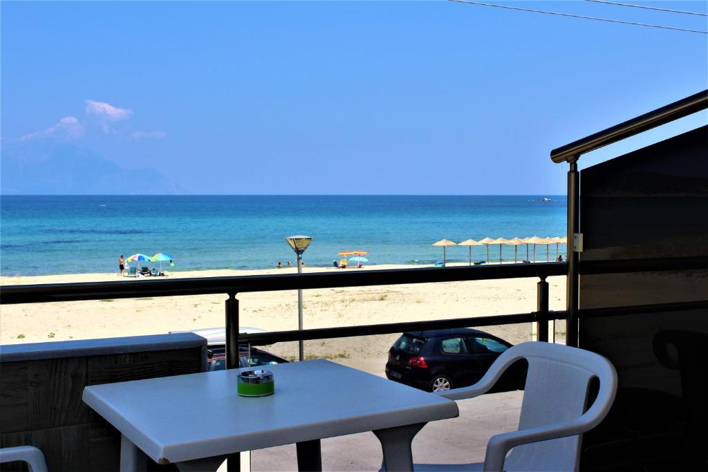 a table and chairs on a balcony with a view of the beach at house giota in Sarti