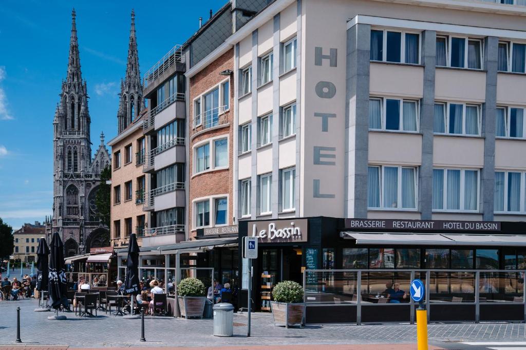 a building on a city street with a church at Hotel du Bassin in Ostend