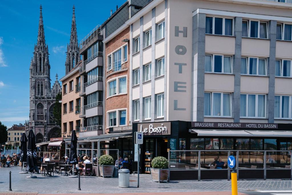 - un bâtiment dans une rue de la ville avec une église dans l'établissement Hotel du Bassin, à Ostende