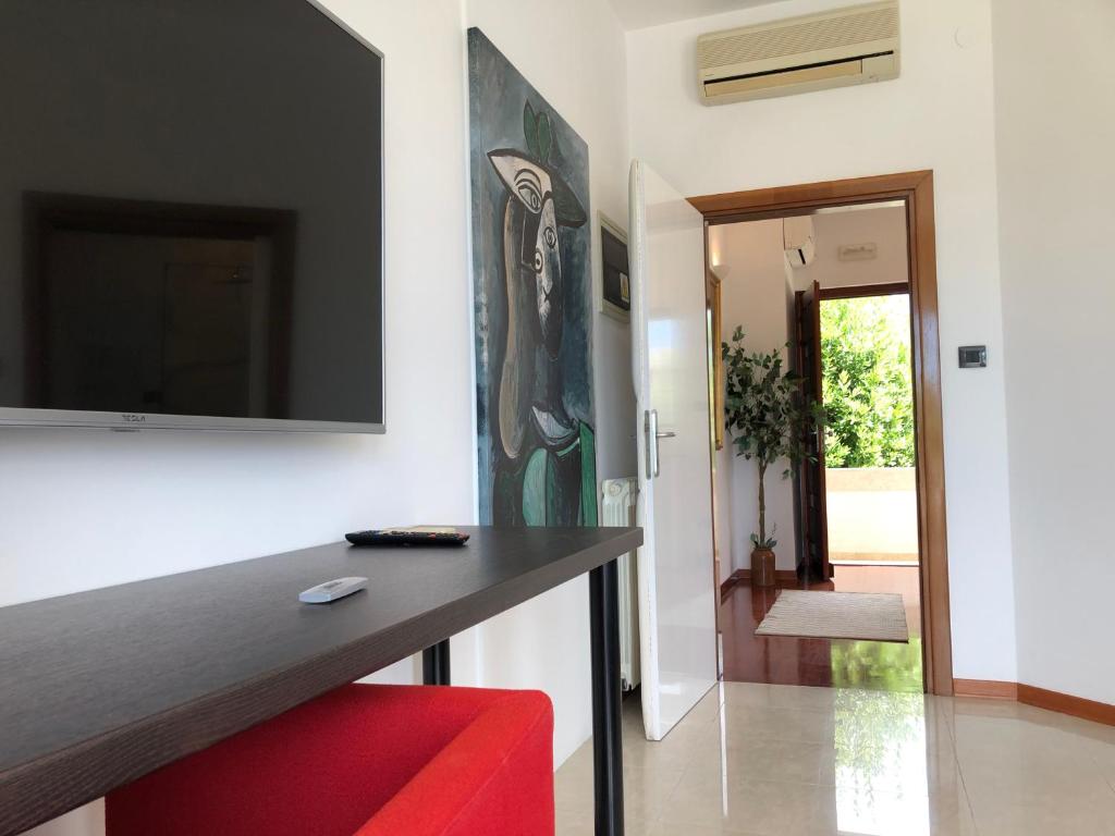 een woonkamer met een rode stoel en een televisie aan de muur bij STUDIO LYCIA TOP 2020 in Rovinj