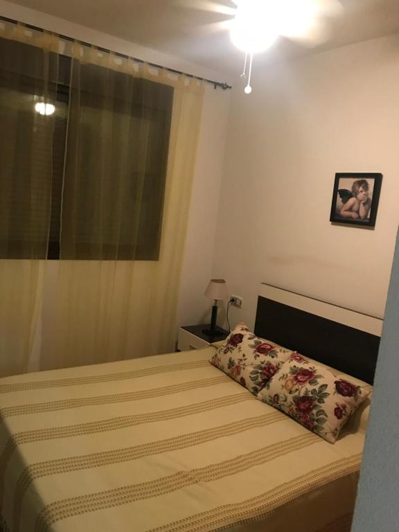 a small bedroom with a bed and a window at Apartamento María Isabel en Los Collados Golf - Aguilas in Águilas