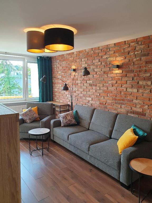 a living room with two couches and a brick wall at 13 Sopot in Sopot