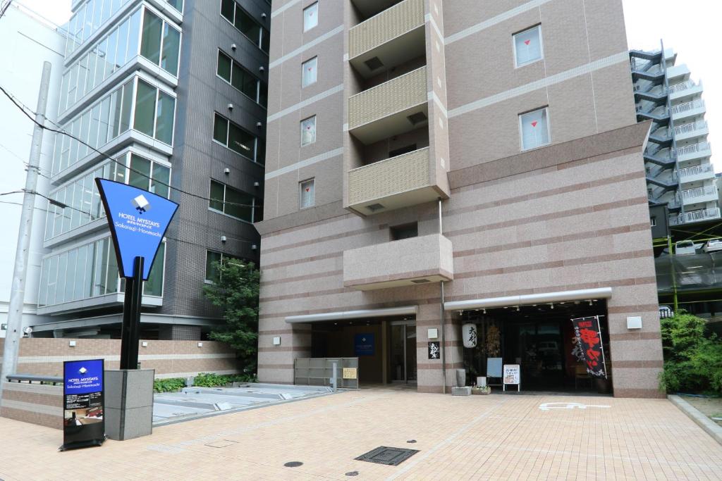 budynek z niebieskim znakiem przed nim w obiekcie HOTEL MYSTAYS Sakaisuji Honmachi w Osace