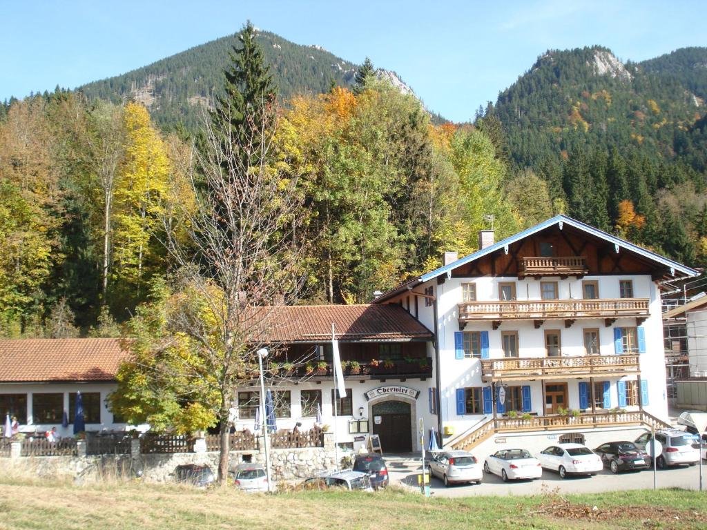 un grande edificio con macchine parcheggiate di fronte di Pension Oberwirt a Fischbachau