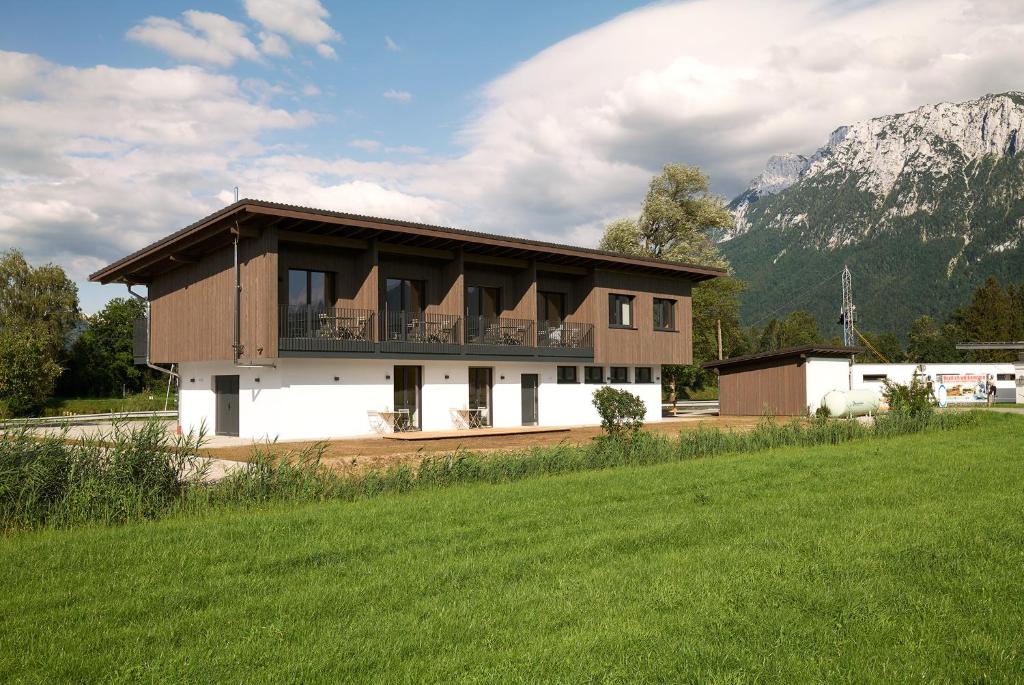 una casa con balcone sul lato di un campo di Water, Ski & Mountain Lodge a Kiefersfelden