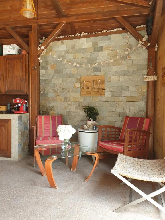 a patio with two chairs and a table with a vase of flowers at Casa Hortensia in Mangalia