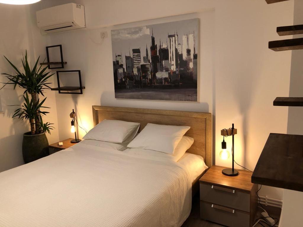 sypialnia z białym łóżkiem i 2 szafkami nocnymi w obiekcie Downtown chic w Jassach