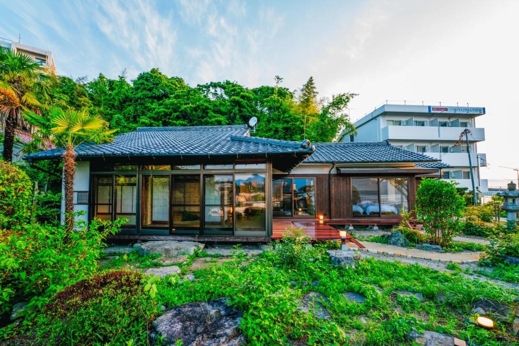 a small house in the middle of a garden at Ajina House - Vacation STAY 84934 in Hatsukaichi
