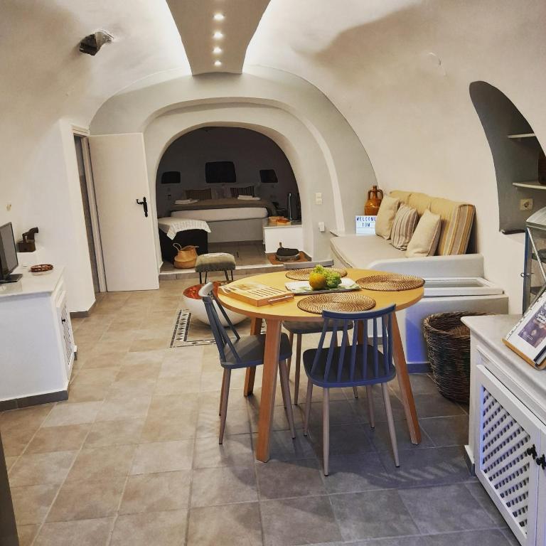 kuchnia i salon ze stołem i krzesłami w obiekcie Cave house mARTrona w mieście Foinikiá
