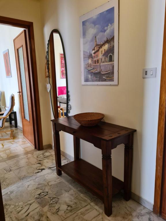 Habitación con mesa de madera y espejo. en Casa dell amore 1 en Sanremo