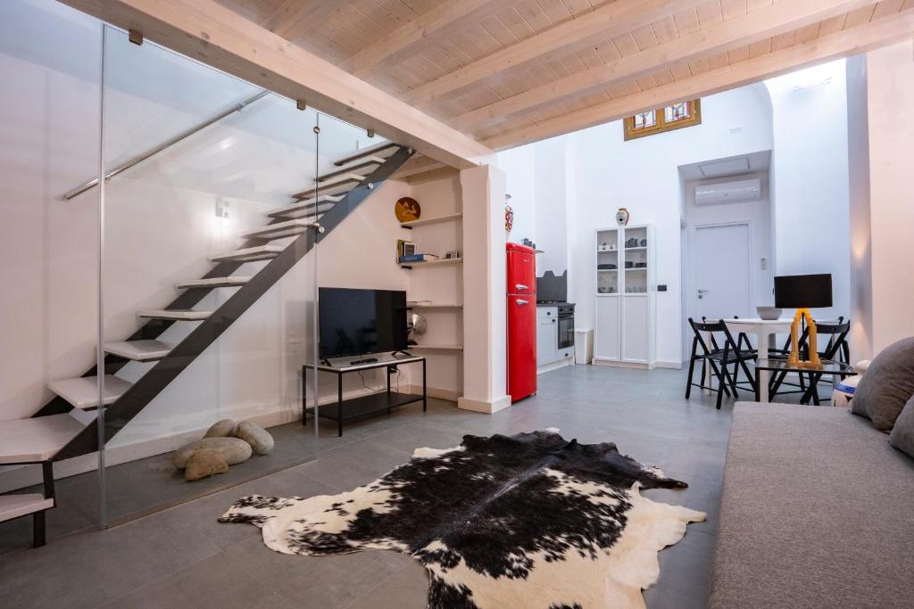 uma sala de estar com uma escada em espiral e uma sala de estar em Ursino tiny house em Catânia