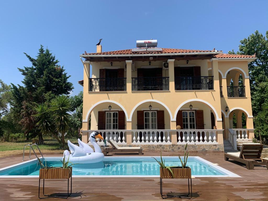 a house with a swimming pool in front of a house at Villa Fos in Gaïtánion