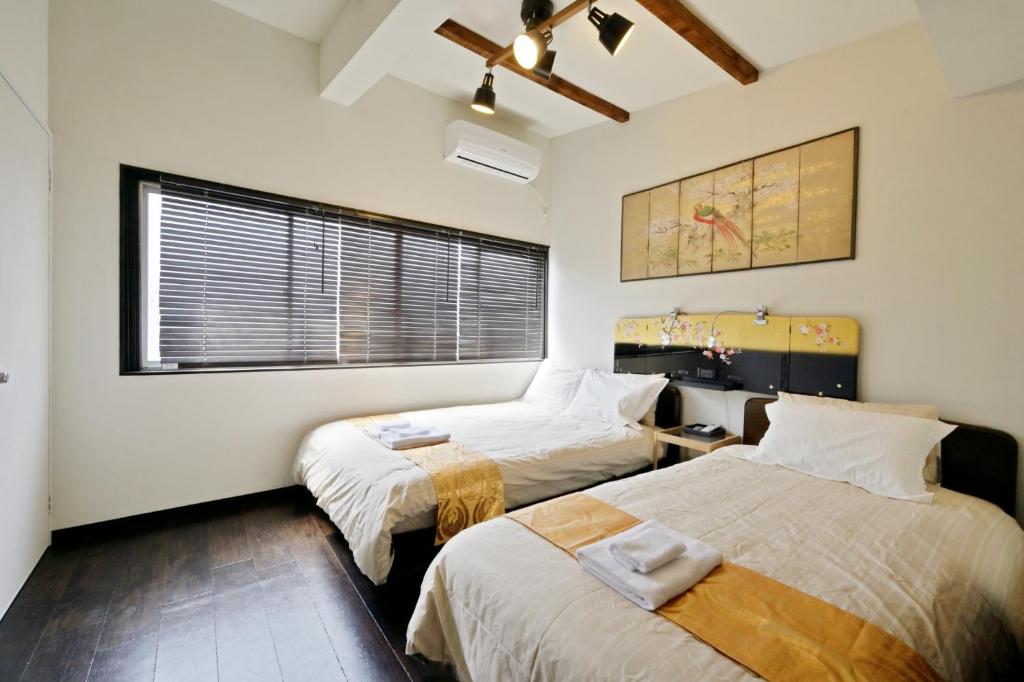 a bedroom with two beds and a window at Abenosujisou - Vacation STAY 8416 in Osaka