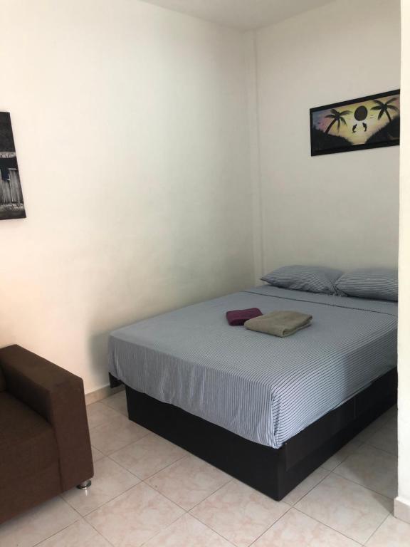 a bedroom with a bed and a chair at Casa yoana in Playa del Carmen