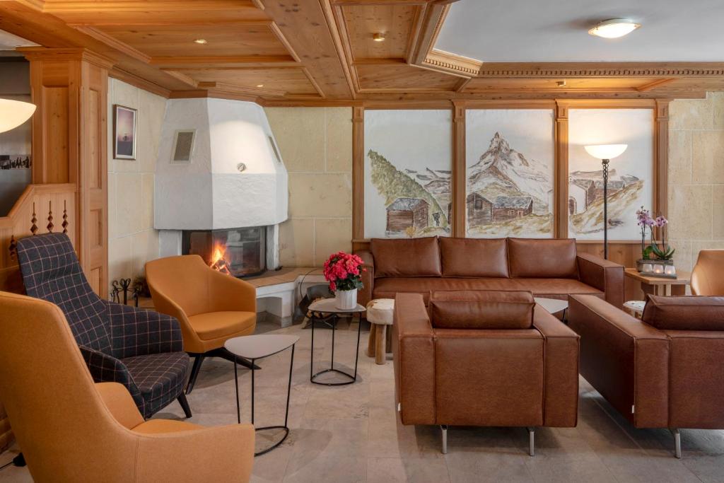 uma sala de estar com um sofá e cadeiras em Hotel Matterhornblick em Zermatt