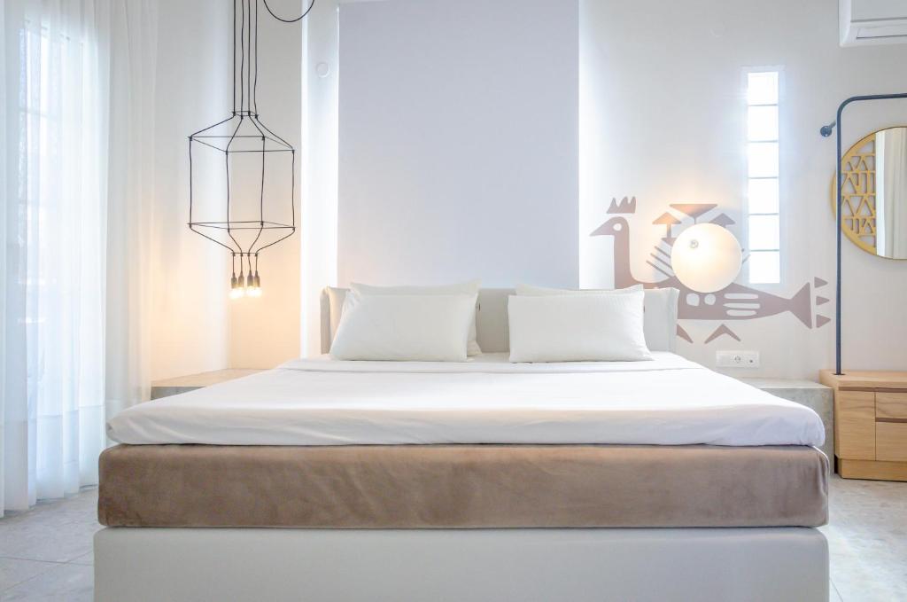 a bedroom with a large bed with white sheets at Egeo in Limenas