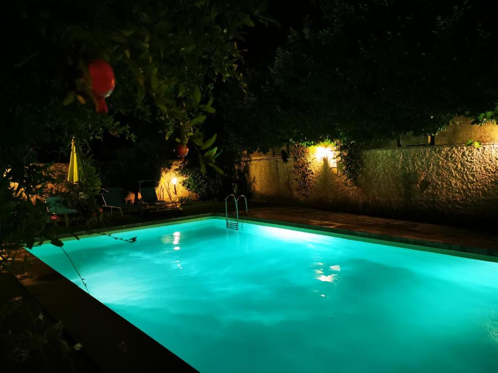 uma piscina azul à noite com luzes em Lou Pauseto em Aubagne