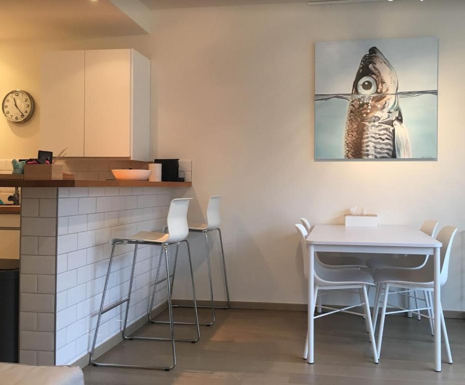 una cocina con mesa y sillas y una foto de pájaro en la pared en Appartement Giulia, en Knokke-Heist