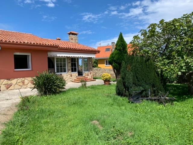 una casa con un gran arbusto en el patio en Stella Maris, en Villaviciosa