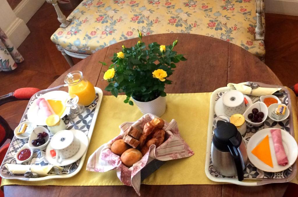 Chambre d'hôtes Le Petit Tertre في ديجون: طاولة عليها طبقين من طعام الإفطار