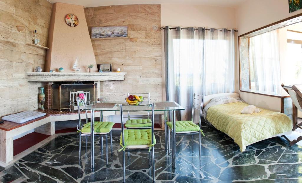 een kamer met een tafel en stoelen en een open haard bij Iro - Kostas House 1 in Chalkida