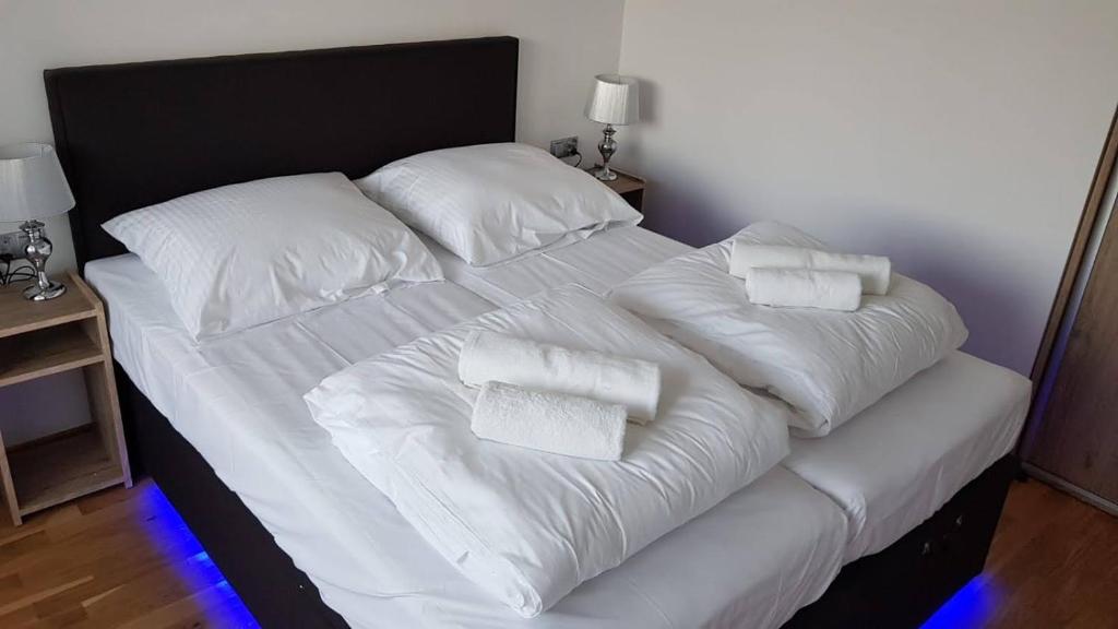 コウォブジェクにあるApartament Bałtyckaの大型ベッド(白いシーツ、枕付)