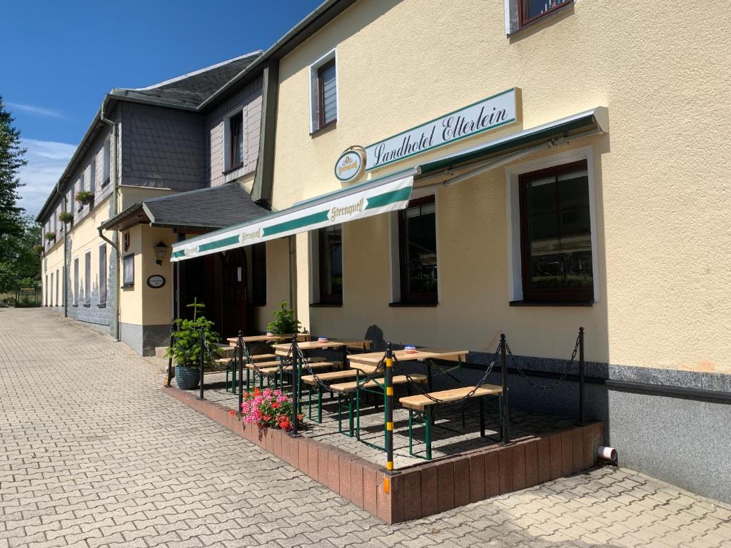 ein Restaurant mit Tischen und Stühlen außerhalb eines Gebäudes in der Unterkunft Landhotel Elterlein in Elterlein
