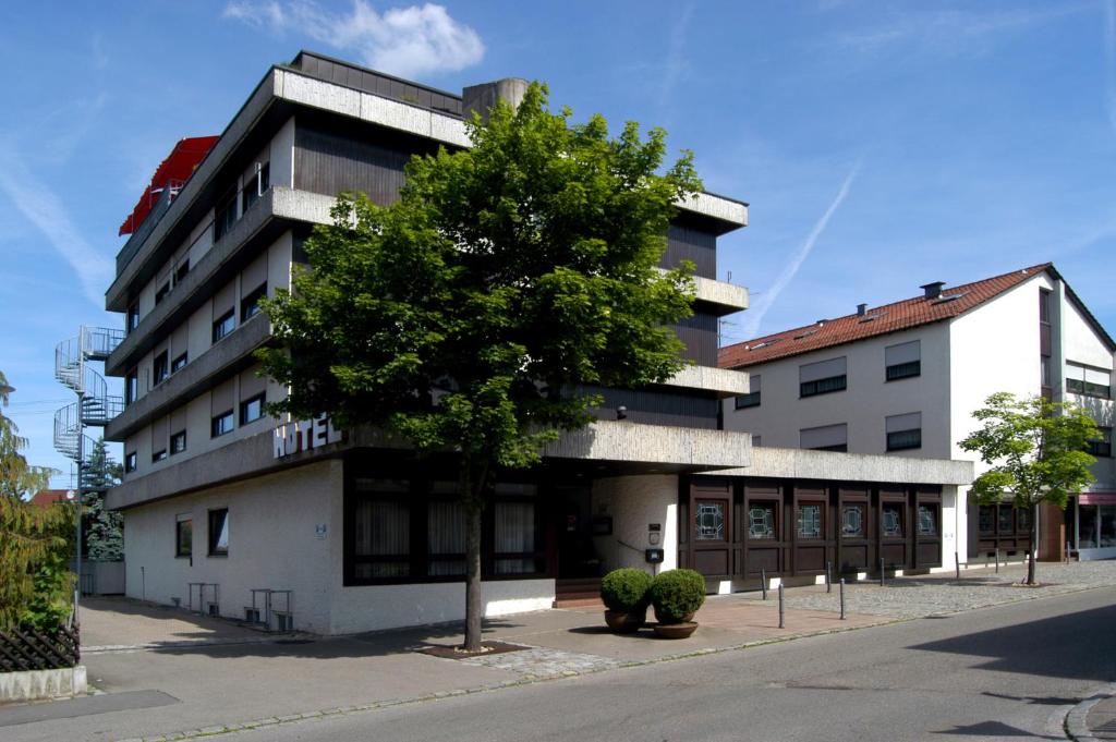 ein Gebäude mit einem Baum davor in der Unterkunft Hotel Krone in Steinenbronn