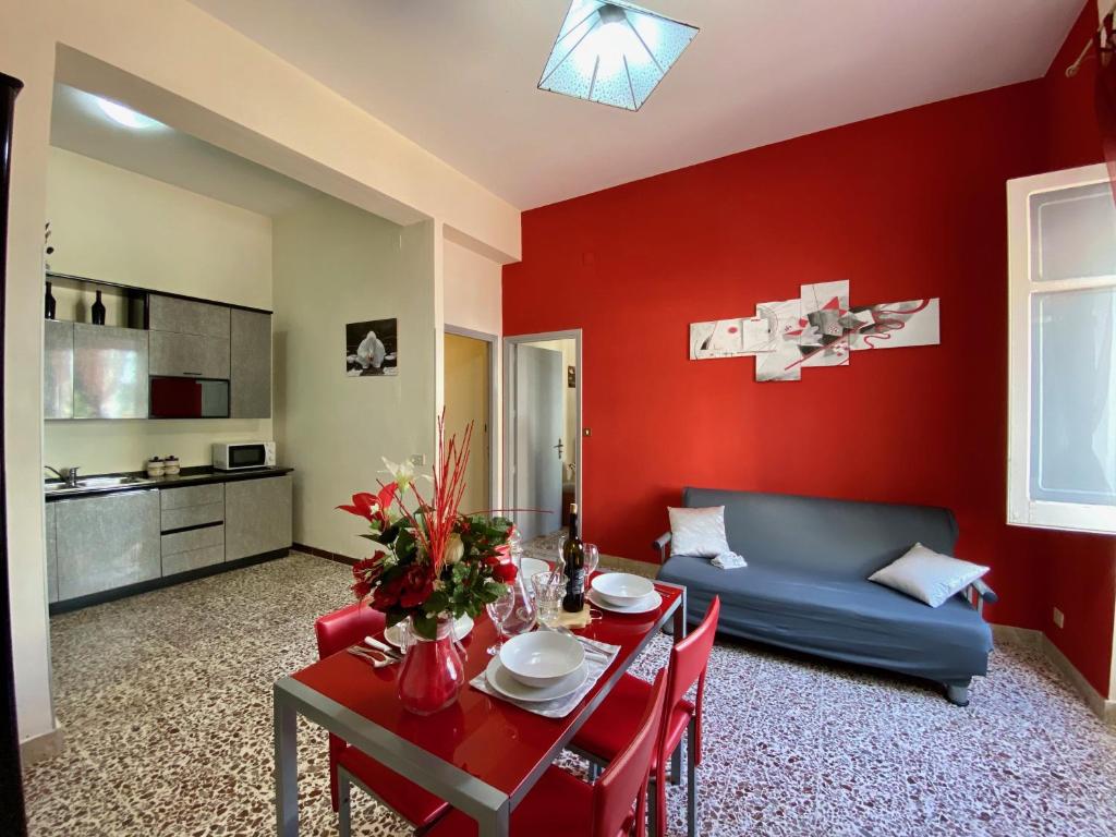 un soggiorno con divano blu e parete rossa di La Casa di Anita a Cefalù