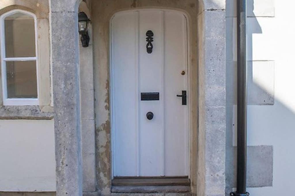 - une porte blanche dans un bâtiment avec fenêtre dans l'établissement Curzon House, à Calne