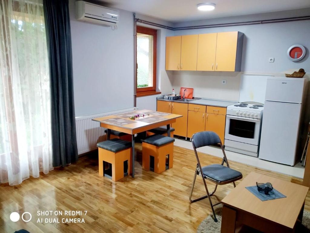 een keuken met een tafel en stoelen in een kamer bij IDI MI - DODJI MI in Vrnjačka Banja