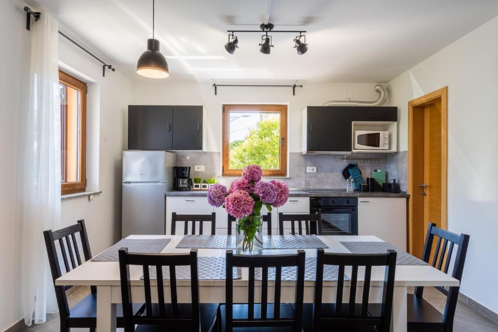 kuchnia ze stołem, na którym stoi wazon z kwiatami w obiekcie Downtown Apartment Helena w mieście Opatija