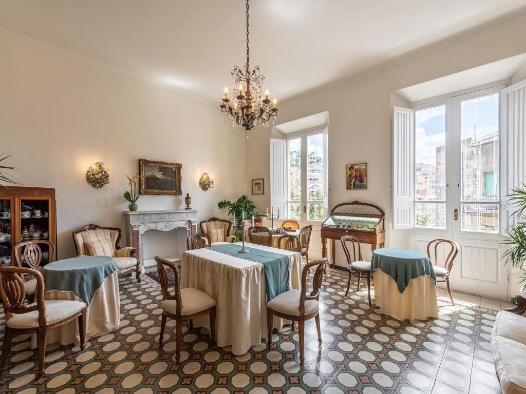 un comedor con mesas y sillas y una lámpara de araña en Palazzo Santa Caterina, en Dorgali