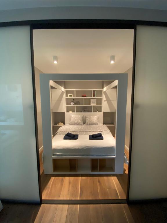 Cette chambre comprend un lit avec un miroir. dans l'établissement Błękitny Apartament - Wilanów, à Varsovie