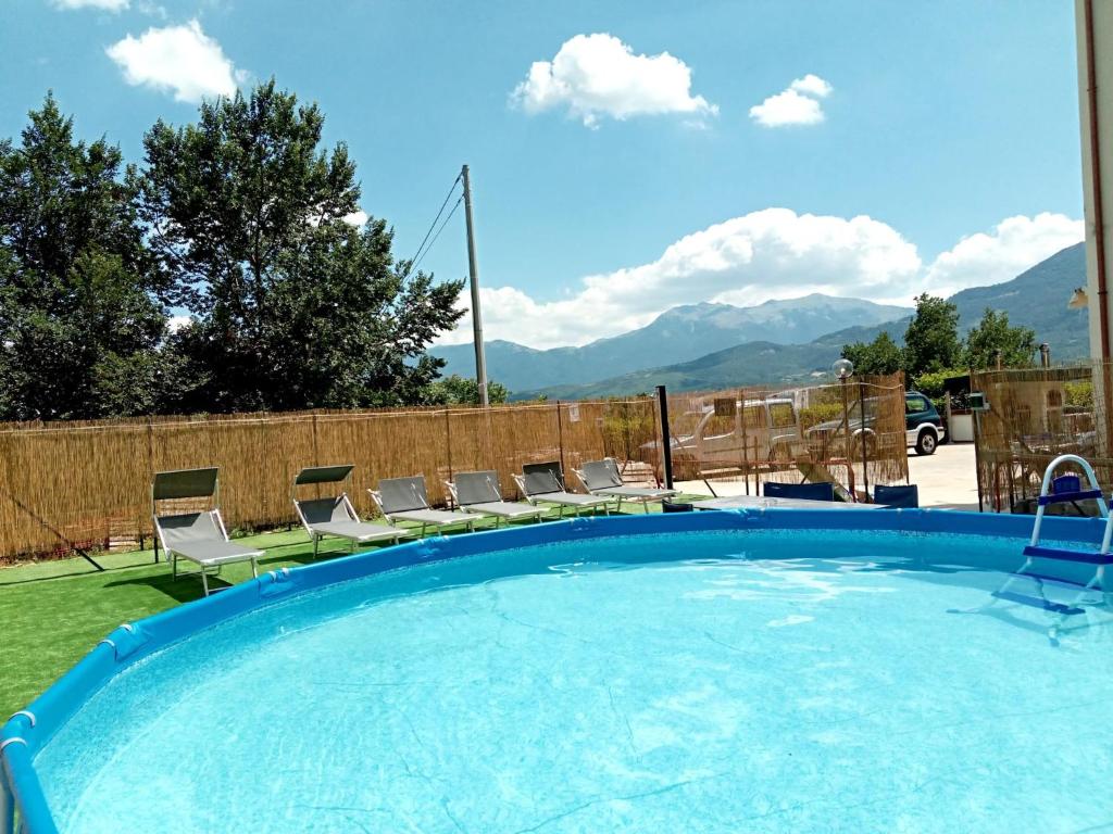 uma grande piscina com cadeiras e vista para as montanhas em Villa Santa Maria em Santa Maria del Molise
