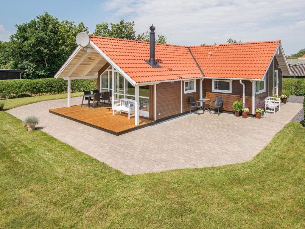 Sønder BjertにあるThree-Bedroom Holiday home in Bjert 2のオレンジ色の屋根とパティオ付きの家