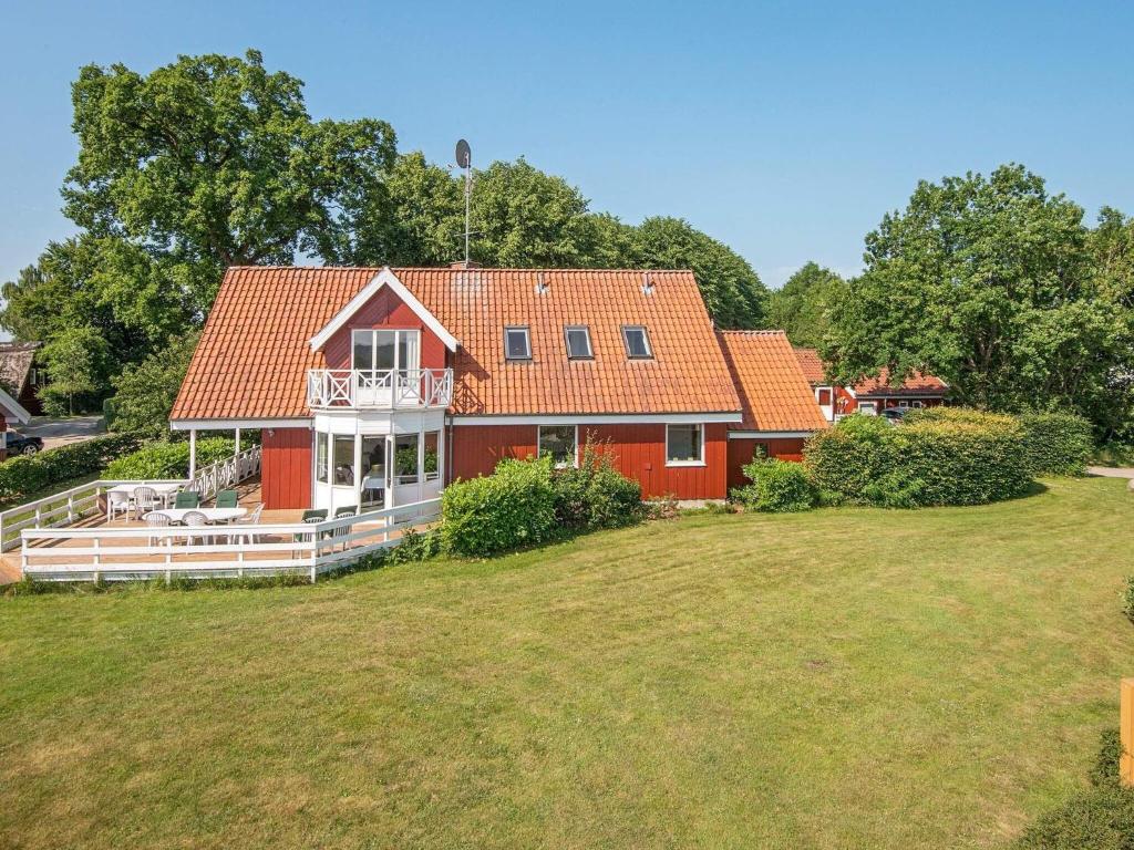 a red house with an orange roof on a yard at 8 person holiday home in Haderslev in Kelstrup Strand